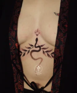 Mini snake tattoo on chest for female